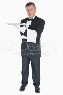 Happy waiter with silver tray and towel