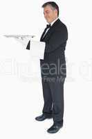 Waiter holding silver tray and towel