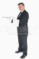 Waiter holding silver tray while is looking into the camera