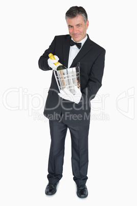 Waiter offering bottle of champagne in cooler