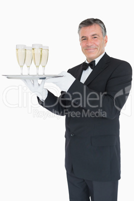 Smiling waiter holding tray with glasses with champagne