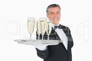 Waiter serving tray full of glasses with champagne