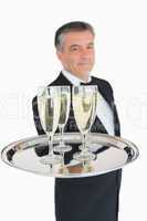 Waiter holding out tray with champagne