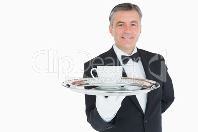 Smiling waiter holding tray with coffee cup