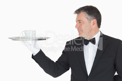 Waiter holding silver tray with cup