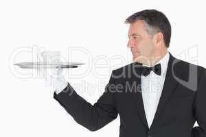 Waiter holding silver tray with cup