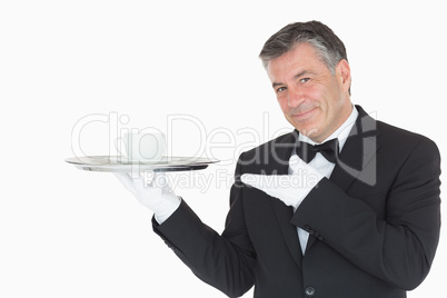 Waiter showing silver tray with cup