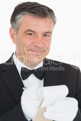 Waiter looking into the camera while is writing into the noteboo