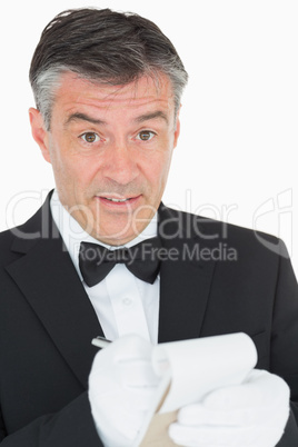 Surprised waiter writing something into notebook