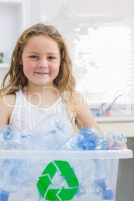 Little girl carrying box full of empty plastic bottles