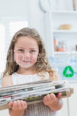 Girl holding old newspapers