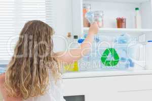 Girl putting bottle in recycling box