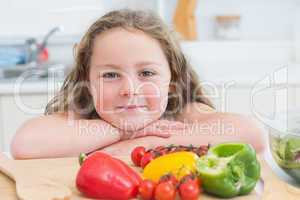 Girl leaning beside vegetables