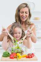 Mother and daughter mixing salad