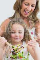 Close up of mother and daughter during mixing salad