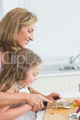 Mother and daughter slicing mushroom together