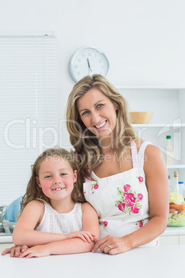 Mother and daughter leaning on table