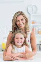 Mother hugging daughter in the kitchen
