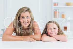 Mother and daughter leaning on table in the kitchen