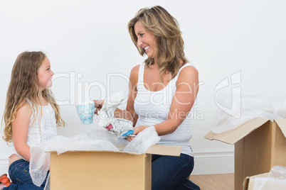 Mother and daughter unpacking mugs