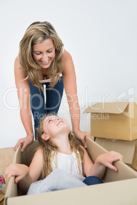 Daughter sitting in the box looking into her mother