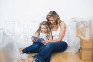 Smiling mother and daughter using tablet computer