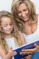 Mother and daughter having fun with tablet computer