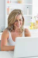 Woman using laptop in the kitchen