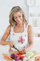 Woman in apron cutting vegetables