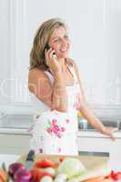 Woman leaning on sink and talking on phone