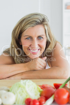 Smiling woman leaning on table