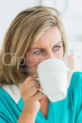 Woman in bathrobe drinking coffee