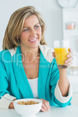 Woman having juice and cereal for breakfast