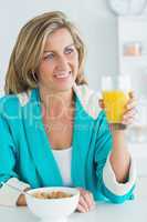 Woman having juice and cereal for breakfast
