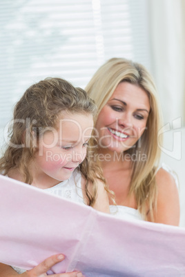 Daughter and mother reading book