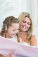 Daughter and mother reading book