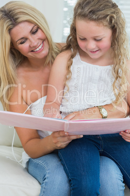 Daughter sitting on mother's lap reading