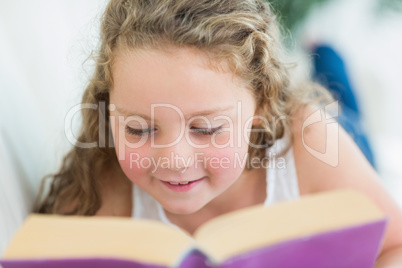 Girl reading a book on the sofa