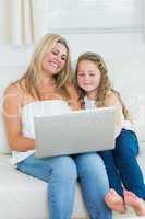 Daughter and mother using notebook