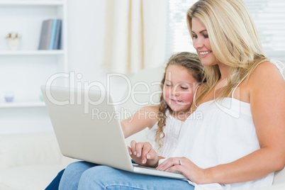 Smiling mother and daughter on the laptop