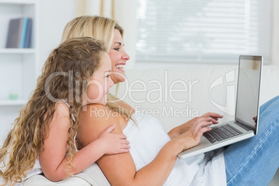 Woman with her daughter using laptop