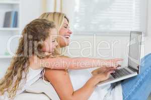 Mother with daughter using laptop