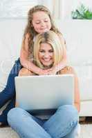 Mother using notebook while sitting on the floor