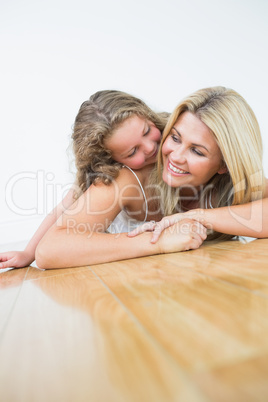 Smiling mother and daughter on the floor