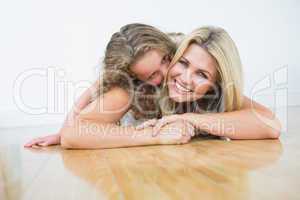 Mother laying with her daughter on the floor