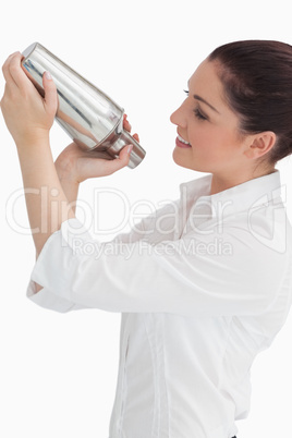 Woman using cocktail shaker while looking at it