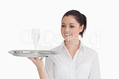 Woman looking on tray with glass