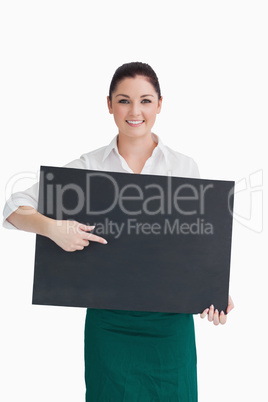 Waitress pointing to black board she is holding