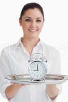 Waitress holding tray with alarm clock