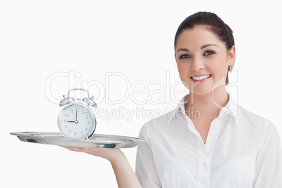 Waitress holding alarm clock on a tray